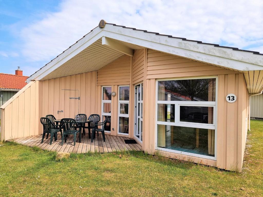 a patio with a table and chairs on a deck at Ferienhaus Strandblick 13 in Brodersby