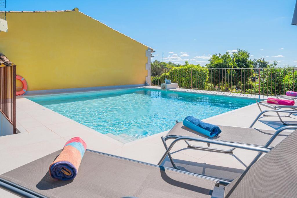 una piscina con 2 tumbonas y una piscina en Son Serra, en Búger