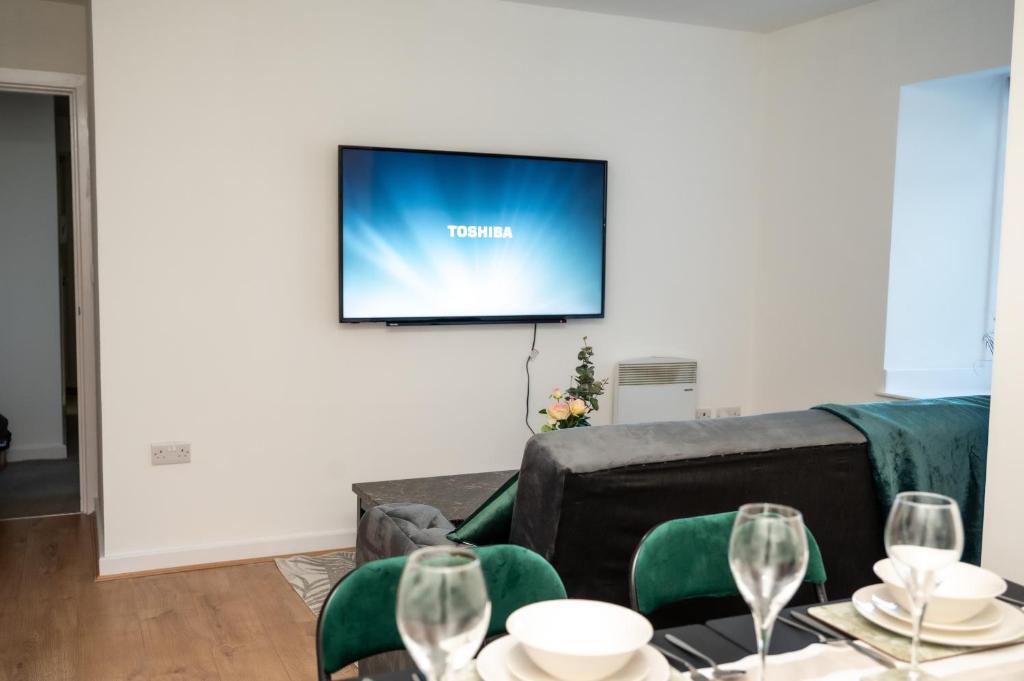 a living room with a couch and a flat screen tv at Bv Charming 2-Bedroom Apartment by Kirkstall Shopping Centre, Free Parking in Leeds