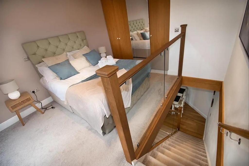 a bedroom with a large bed with a glass railing at Seafront Cottage - The Nook in Cardiff