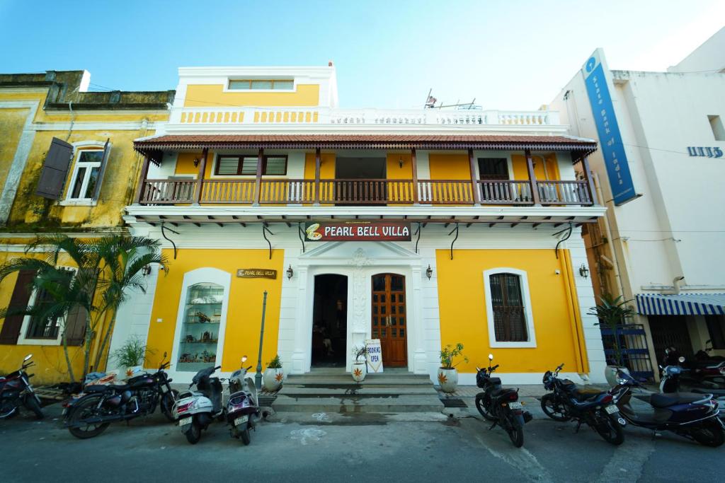 a group of motorcycles parked in front of a yellow building at Pearl bell Villa in Pondicherry