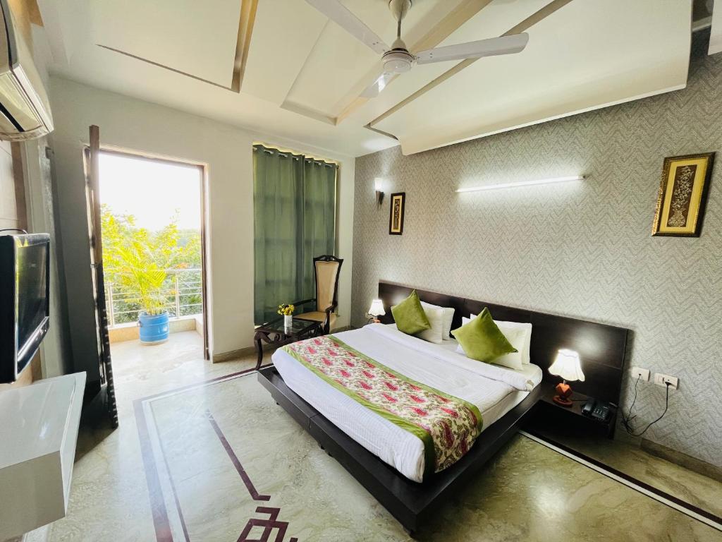 - une chambre avec un grand lit et une grande fenêtre dans l'établissement Hotel Dayal Regency near IMT Chowk Manesar, Manesar, à Gurgaon