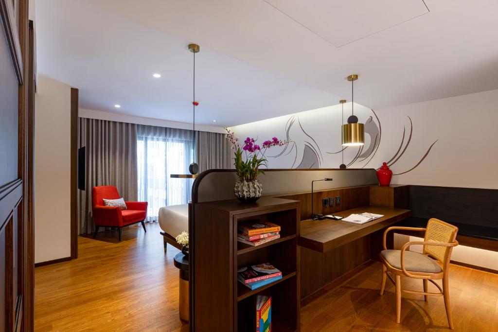 A suite bedroom viewed toward a built-in work desk and separate seating area.