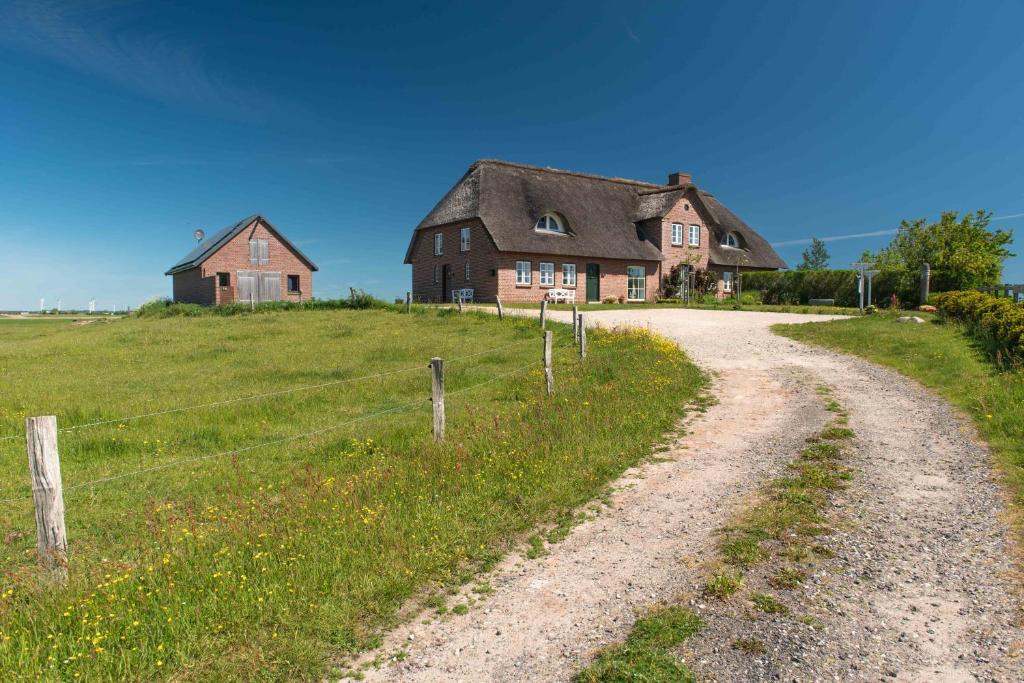 a dirt road in front of an old house at Ferienwohnung Rüm Hart in Hattstedtermarsch