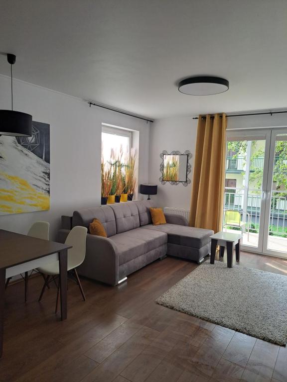 a living room with a couch and a table at Apartament w Bursztynowych Komnatach in Darłówko