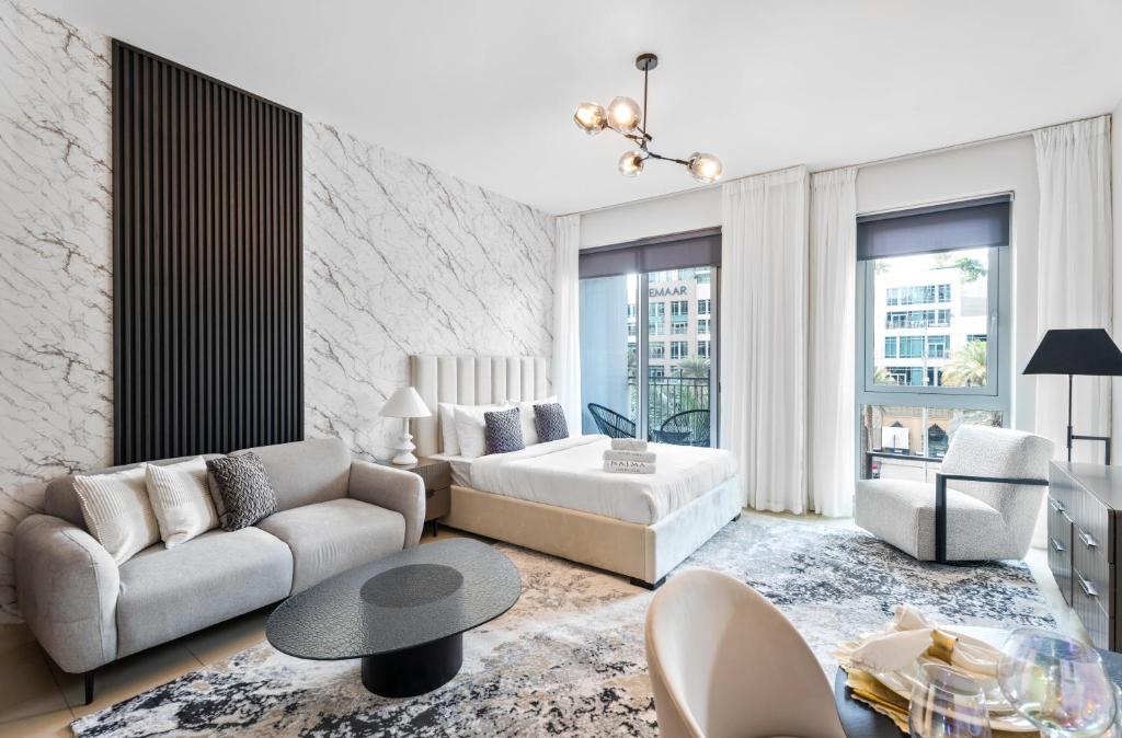 - un salon avec un canapé et un lit dans l'établissement Nasma Luxury Stays - Sophisticated Studio Apartment near Burj Khalifa, à Dubaï