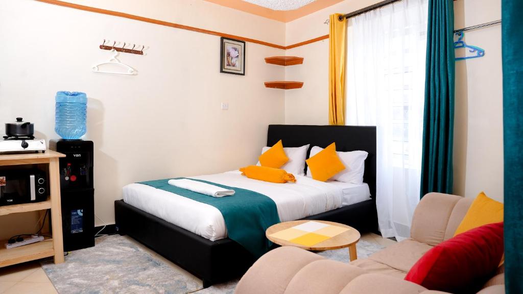 a bedroom with a bed and a living room with a couch at Shalom Apartments in Naivasha