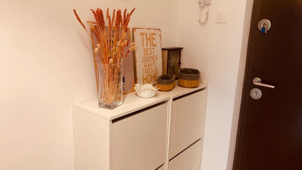 a white cabinet with a vase on top of it at Urban Sunset Loft in Bucharest