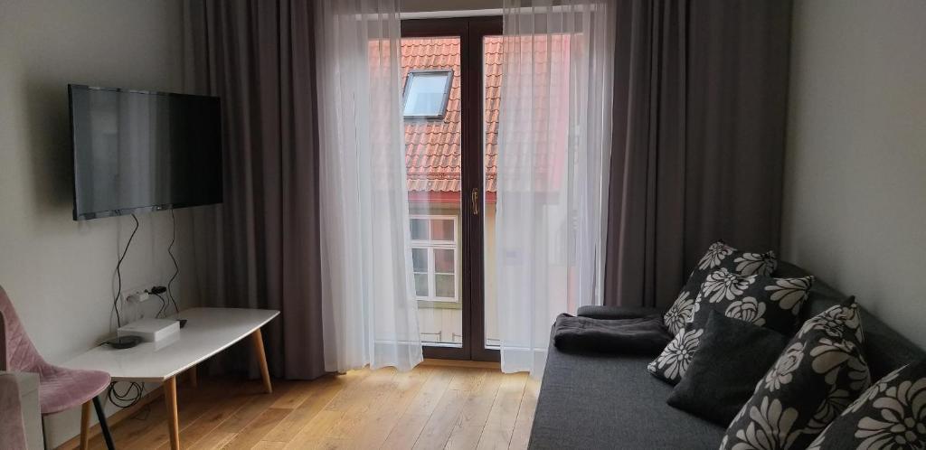 uma sala de estar com um sofá e uma grande janela em Lutsu 12 Apartment - Self check-in em Tartu