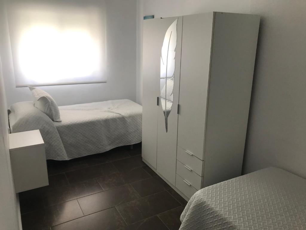 1 dormitorio con 2 camas y armario blanco en Piedra de la Rendona 2, en Conil de la Frontera