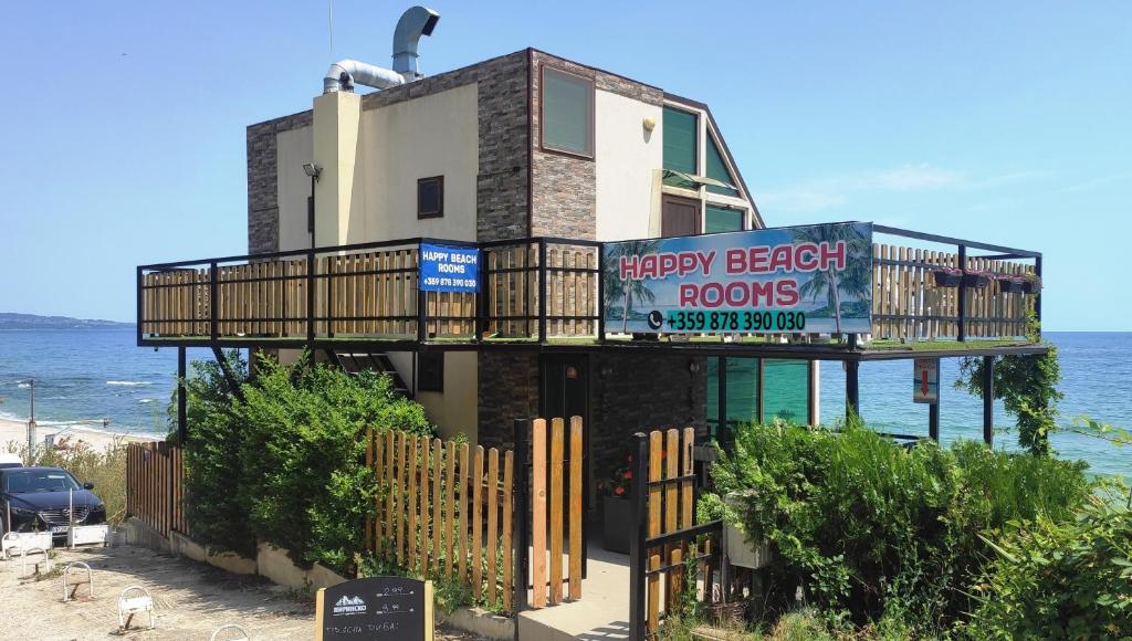 a building with a balcony on the beach at Happy Beach Rooms in Varna City