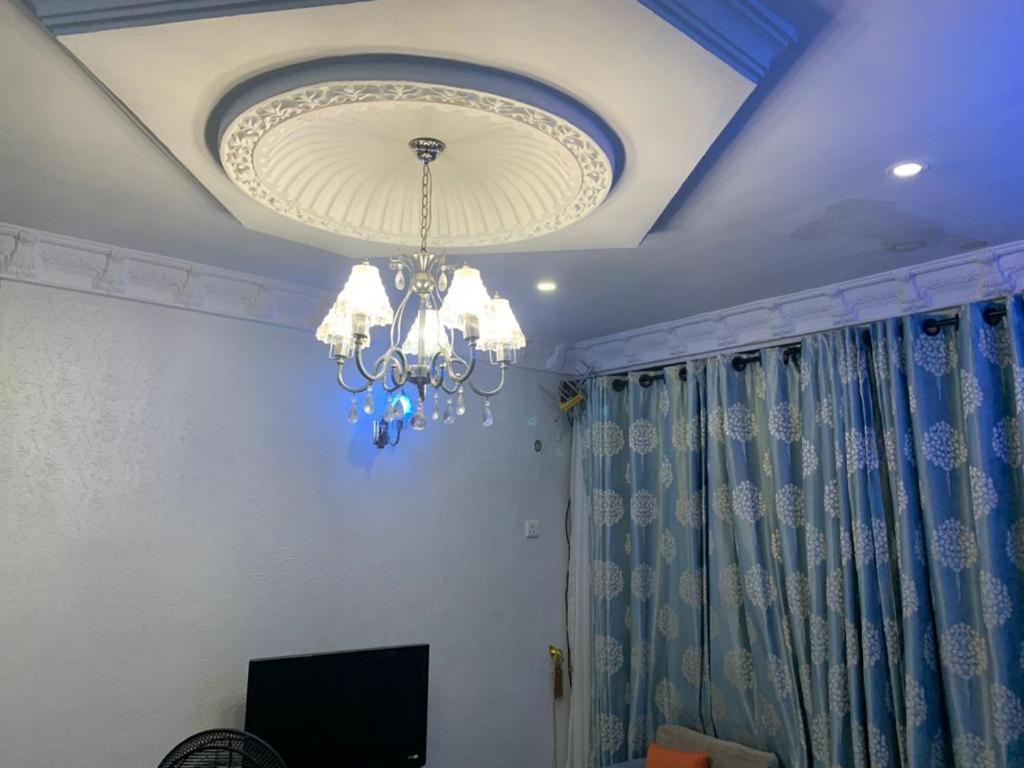 a ceiling with a chandelier in a living room at Grace apartment in Ofatedo