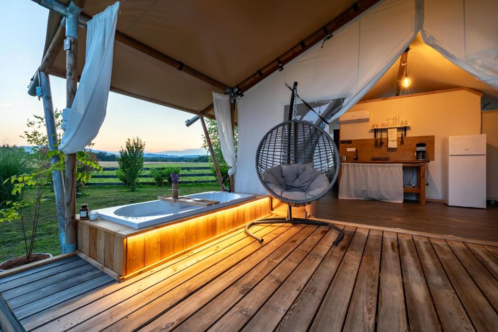 Zimmer mit Badewanne auf einer Holzterrasse in der Unterkunft Glamping Kolpa Resort in Gradac