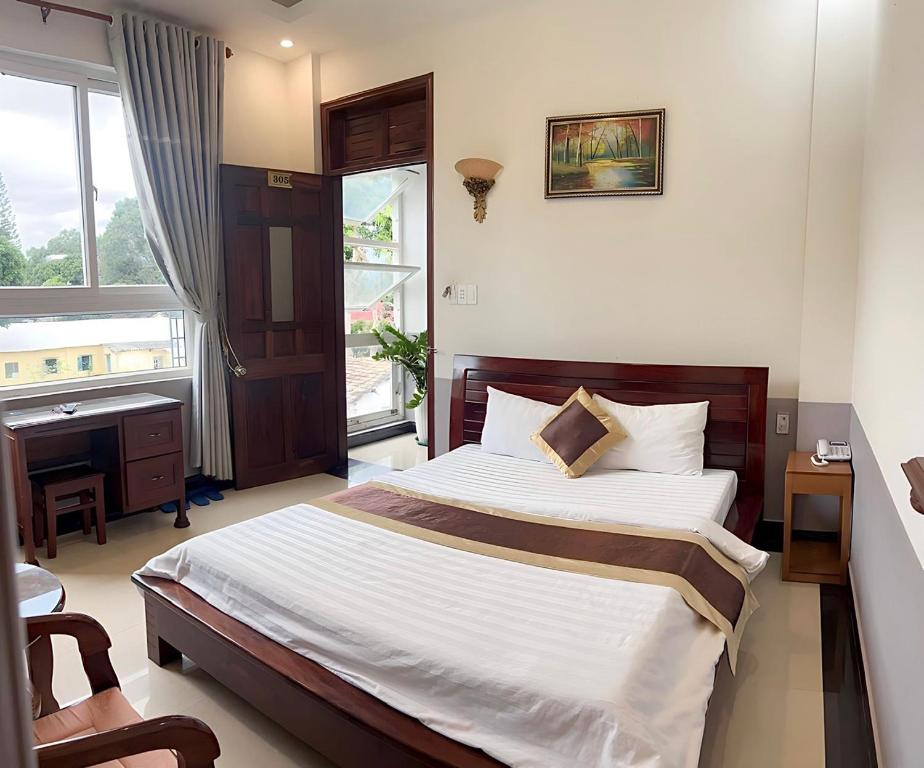 a bedroom with a bed and a desk and a window at Thanh Thu 1 Hotel in Kon Tum