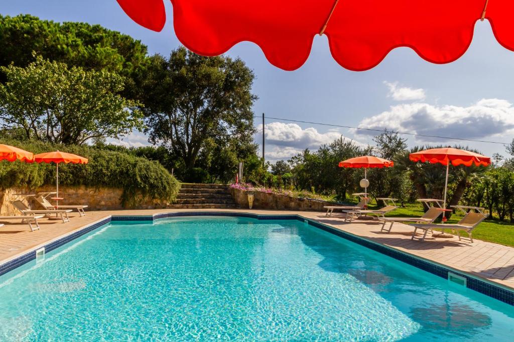 una piscina con 2 sombrillas y sillas en Grillo, en Montiano