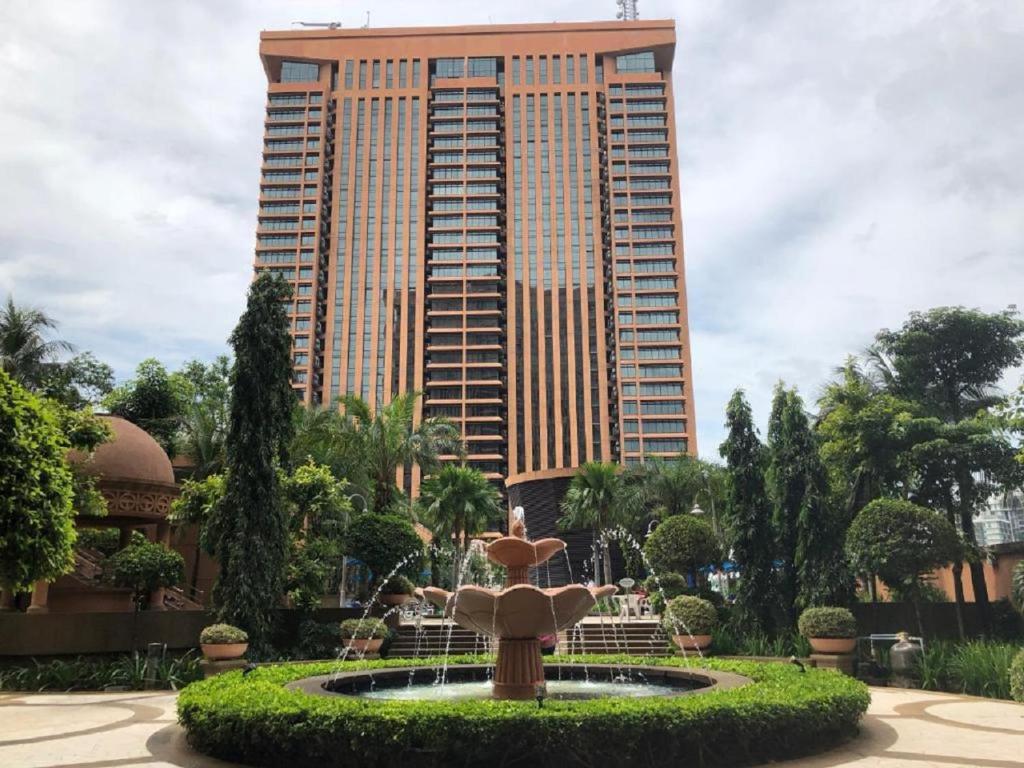 a fountain in front of a tall building at Marmaid Suite At Barjaya Time Square KL in Kuala Lumpur
