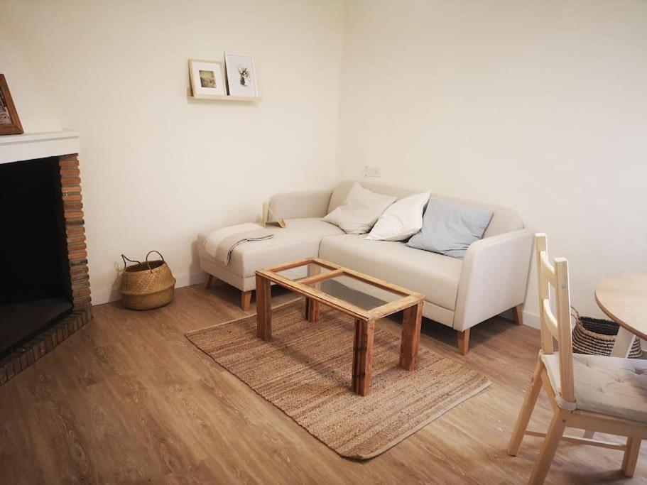 uma sala de estar com um sofá branco e uma mesa de centro em La Casa del Chellero em Enguera