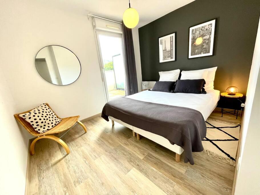 une chambre avec un lit, un miroir et une chaise dans l'établissement L’attique - Standing et Terrasse au centre-ville, à Bellegarde-sur-Valserine