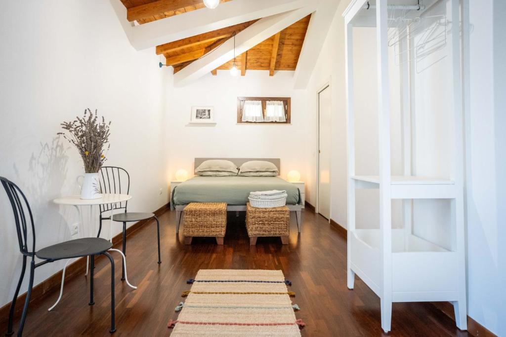 G&B suite في Castelnuovo di Porto: غرفة نوم بسرير وطاولة وكراسي