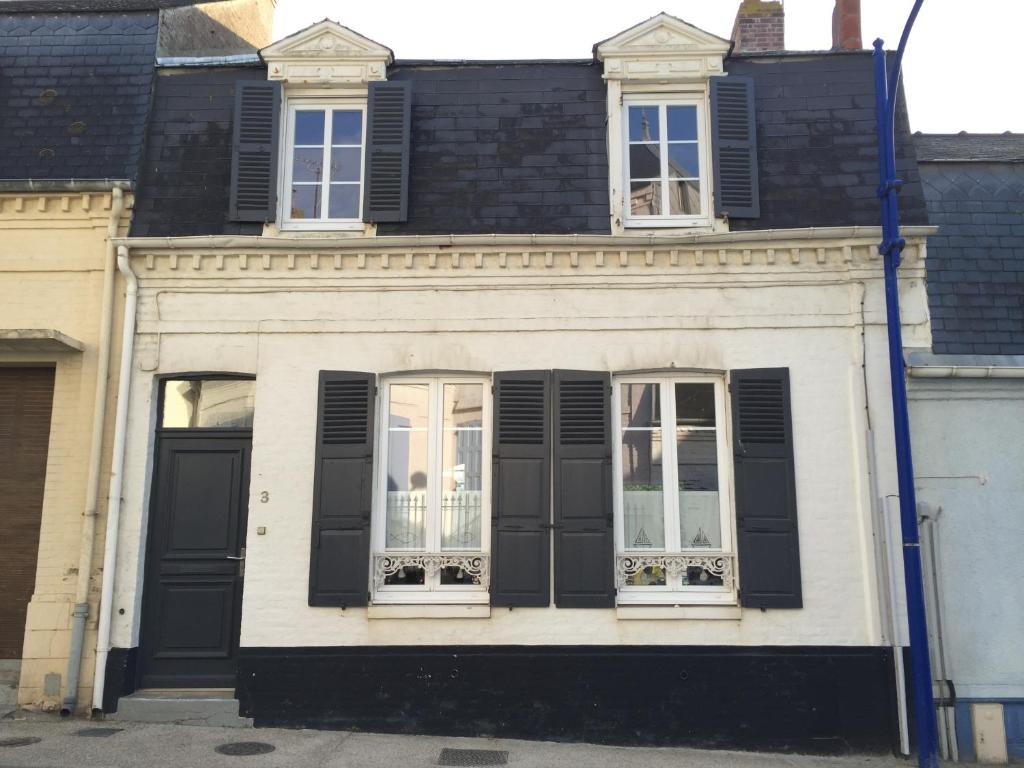 a white house with black shutters and windows at Maison Plage à 50m, Centre Ville avec sa cabine de plage in Le Crotoy