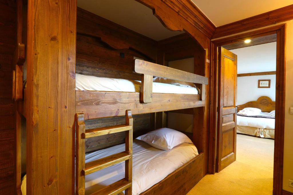 a bedroom with two bunk beds in a cabin at Hôtel Les Peupliers in Courchevel