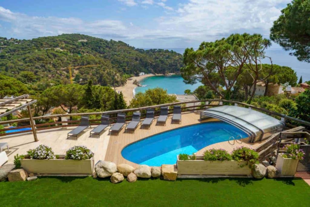 羅列特海岸的住宿－Villa Mitjorn Cala Canyelles，一个带椅子的游泳池,享有海滩美景