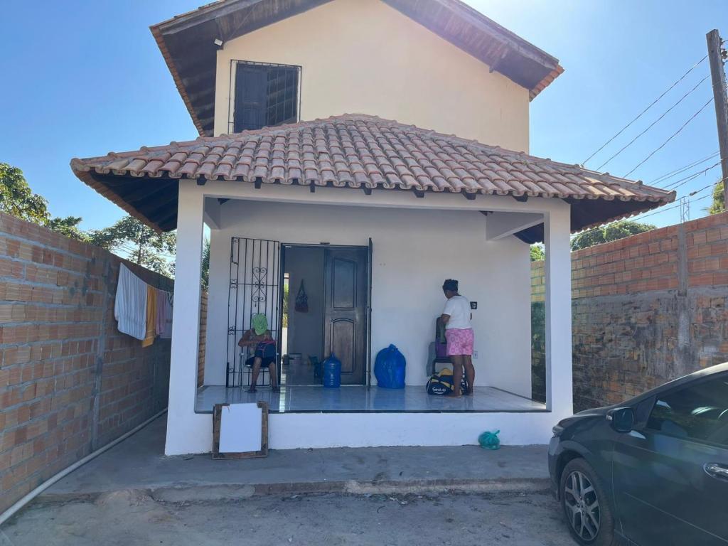 ein kleines Haus mit einer Veranda und einem Auto in der Unterkunft Chalé meu príncipe in Marapanim