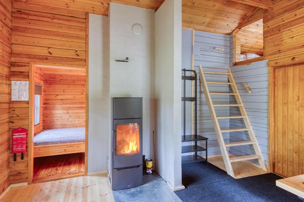 Cabaña de madera con chimenea y escalera en Pinetree Cottages Cozy log cabin en Kalanti