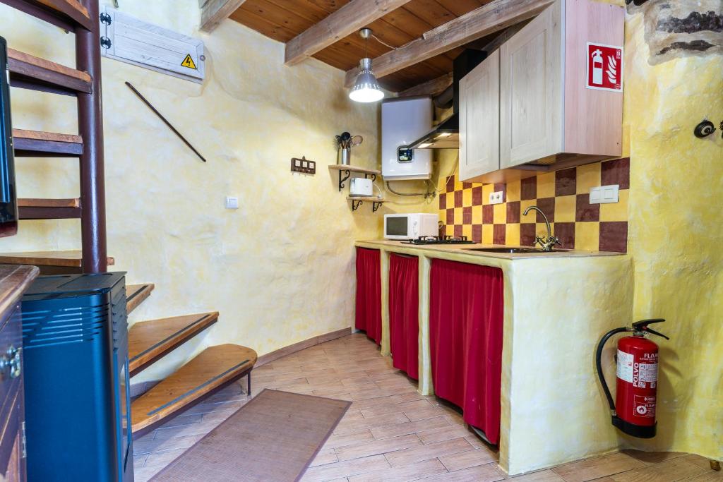 a small kitchen with red cabinets in a room at Casa de turismo rural Sardom2 in Bembibre