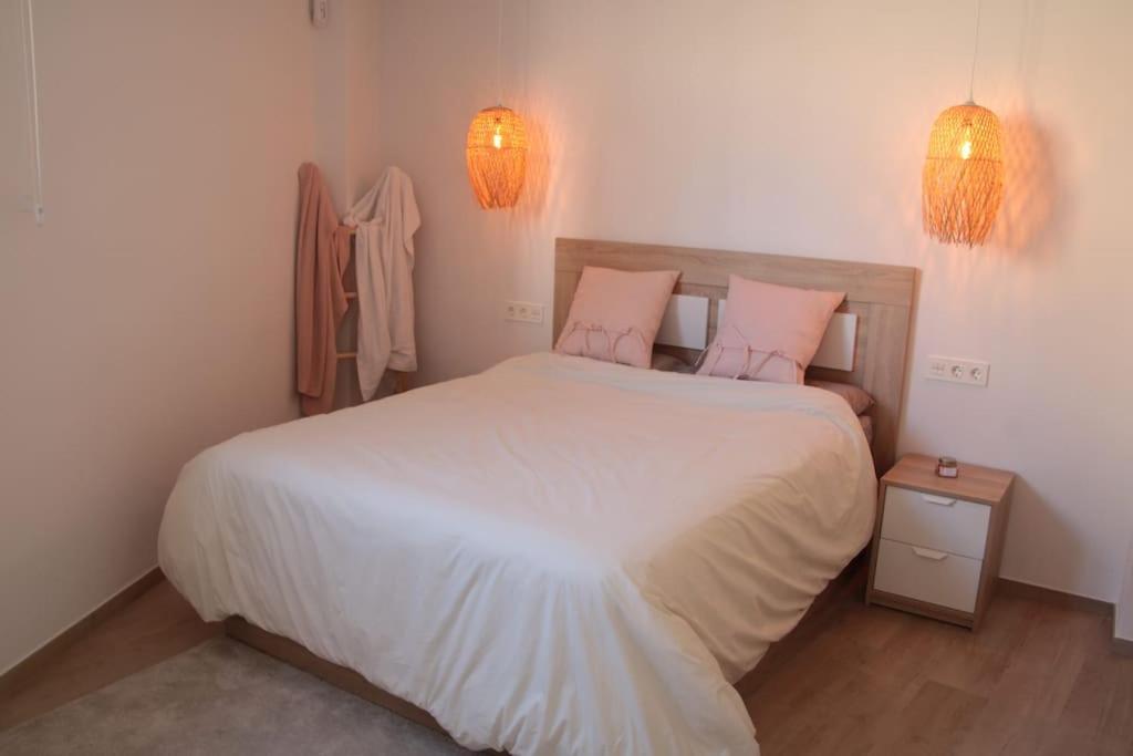 a bedroom with a large white bed with two pink pillows at Ca Lanosa in Alicante