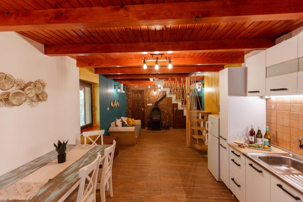 a kitchen with white cabinets and wooden ceilings at PAMPUSKA Apartman in Gyomaendrőd