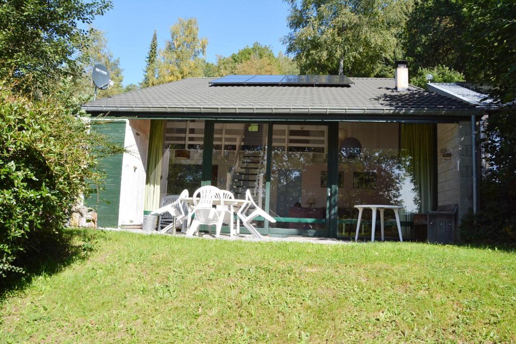 ein Haus mit einer Veranda mit Stühlen darauf in der Unterkunft Huisje in Stavelot in Stavelot