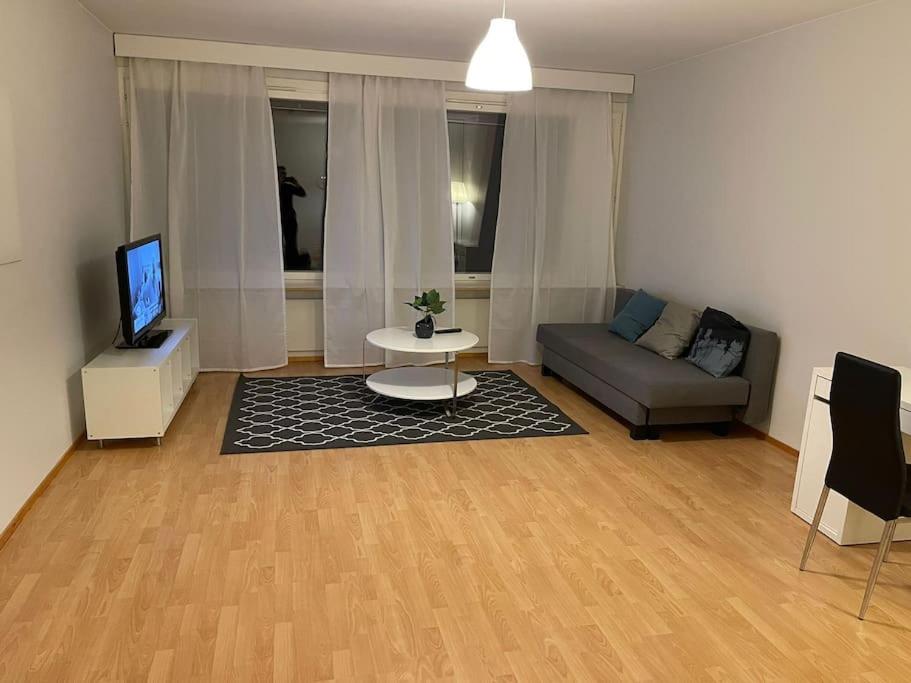 a living room with a couch and a tv at Kotimaailma - Avara hyväkuntoinen kolmio Espoossa in Kauniainen