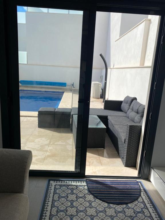 a living room with a view of a swimming pool at New villa, 2 bedrooms private heated pool sleeps up to 6 in Pilar de la Horadada