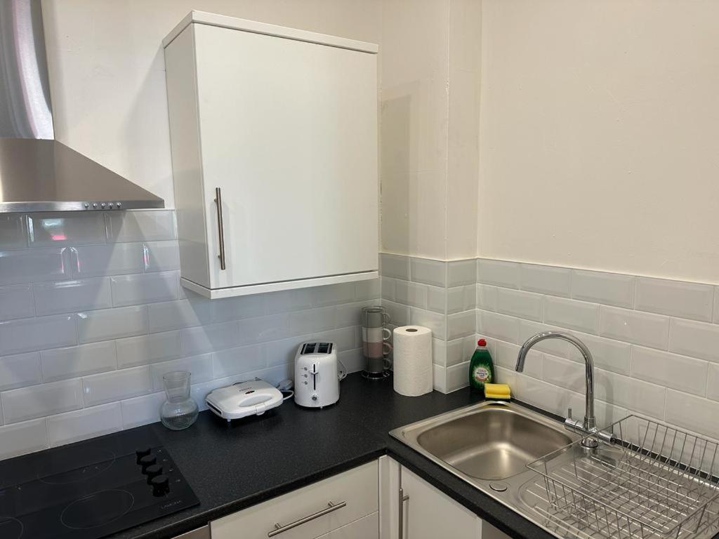 eine Küche mit einer Spüle und einer Arbeitsplatte in der Unterkunft Apartments 7 Greenfield Road in Liverpool