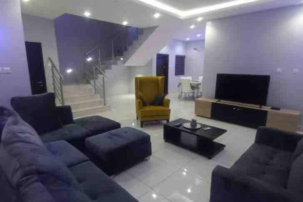 a living room with a couch and a tv at Lekki holiday shortlet in Lekki