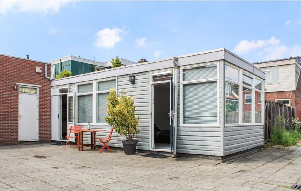 een klein grijs containerhuis met een tafel op een binnenplaats bij Zaandam Cottage Centre - Zaanse Schans Amsterdam in Zaandam