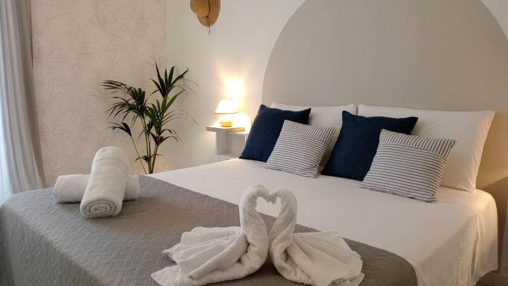 Dos toallas de cisne en una cama en un dormitorio en Meridiana case al mare centro, en Mattinata