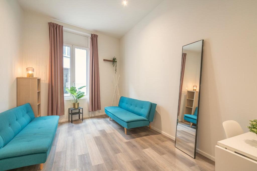uma sala de estar com mobiliário azul e um espelho em Antwerp Center Cozy Cityflats em Antuérpia