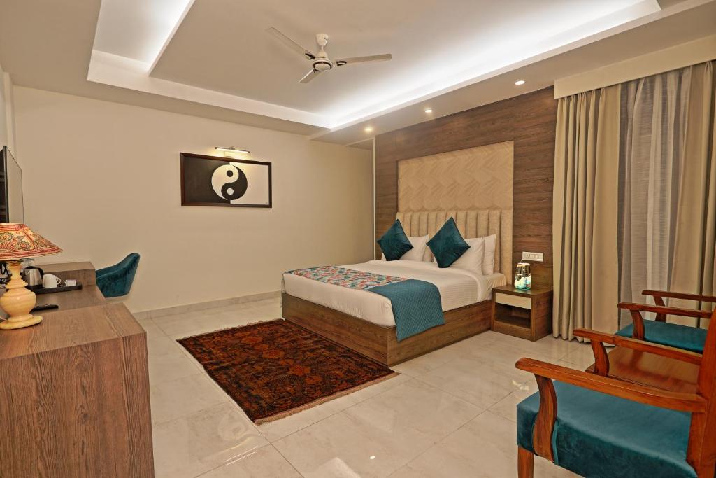 a bedroom with a bed and a chair in a room at Cardinal Express Oxmo in New Delhi