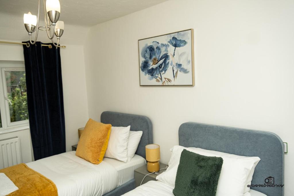 two beds sitting next to each other in a bedroom at Cosy home with private parking in Bloxwich