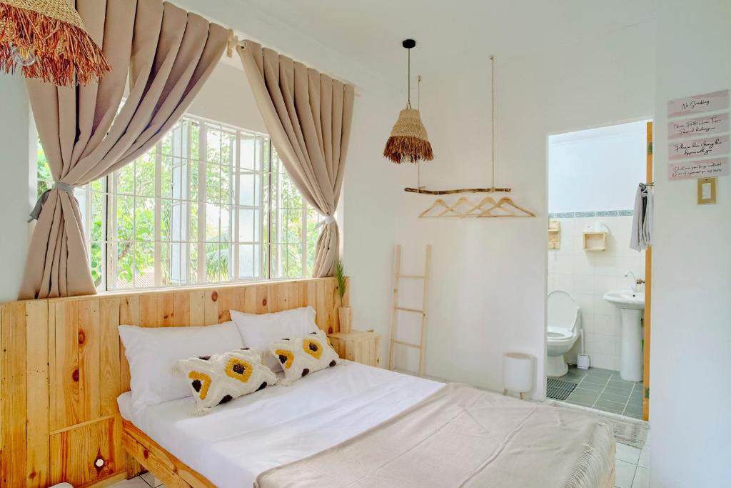 a bedroom with a white bed and a bathroom at Pallet Homes - Landheights Tropics in Iloilo City