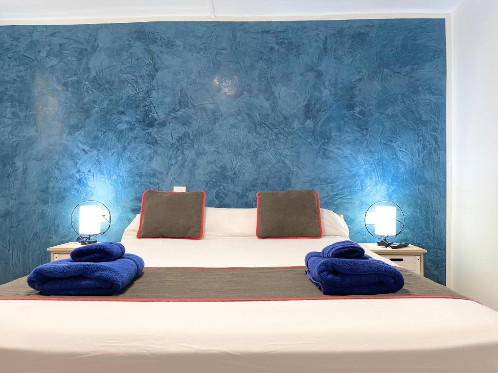1 dormitorio con 1 cama con paredes azules en El Sueño De Alejandra - Apartments en Las Palmas de Gran Canaria