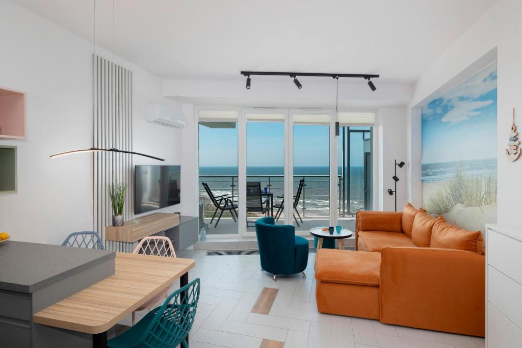 a living room with a couch and a table at Sea View Studio Apartment Porta Mare by Renters Prestige in Dziwnówek