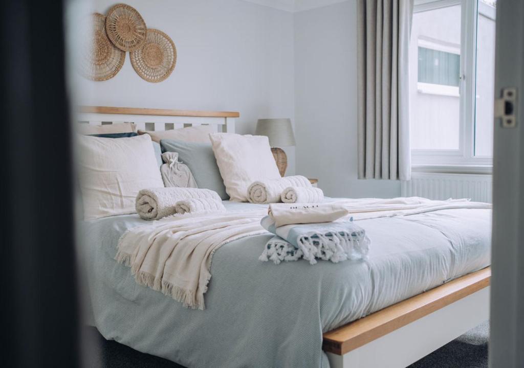 1 dormitorio con 1 cama grande con almohadas blancas en Joannes Retreat, Dog Friendly Property in Weymouth with Free Parking, en Weymouth