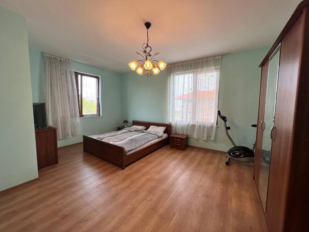 a bedroom with a bed and a chandelier at Къща Каменар in Pomorie