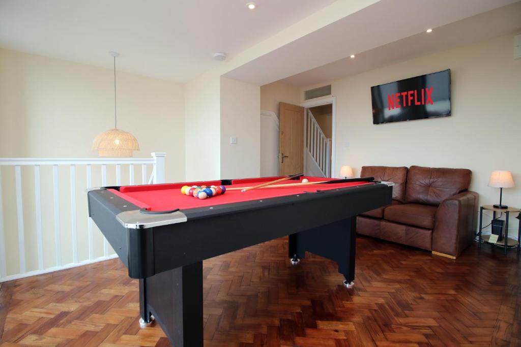 a living room with a pool table and a couch at LUXURY 4 Bedroom 4 Ensuite Home in Penarth (Pool Table Games Room & BBQ Garden) with Sea Views in Cardiff