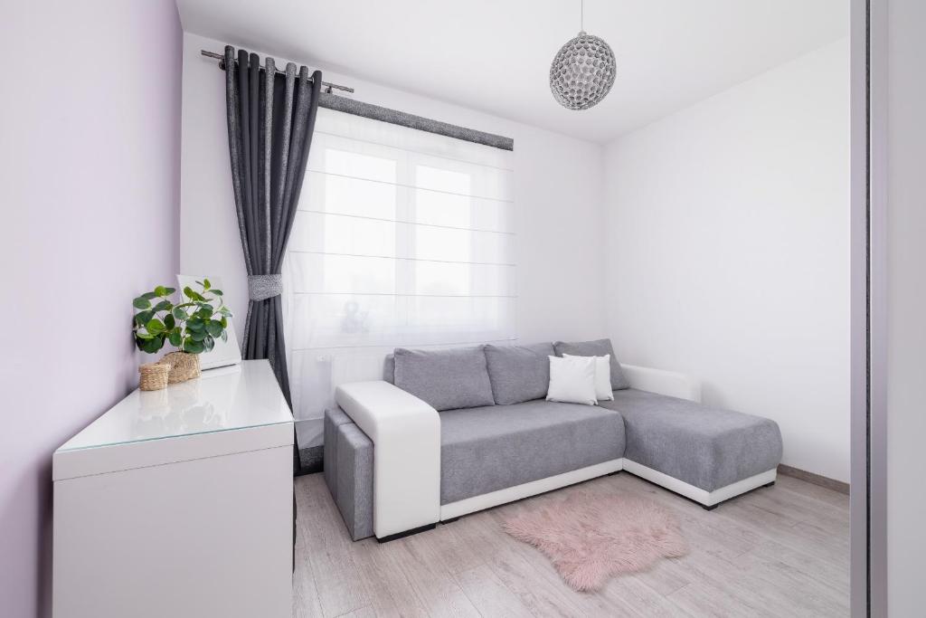 a living room with a couch and a window at Cracow Prądnik Spacious & Family Apartment with 3 bedroom by Renters Prestige in Krakow
