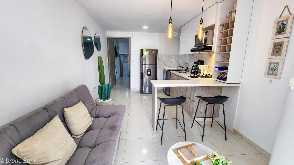 een woonkamer met een bank en een keuken bij Apartamento céntrico con suave cama y wifi gratuito! in Cali