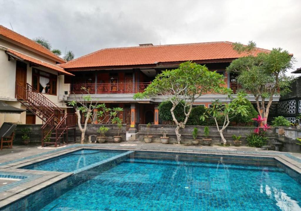 a swimming pool in front of a house at Pande Permai Bungalows in Ubud